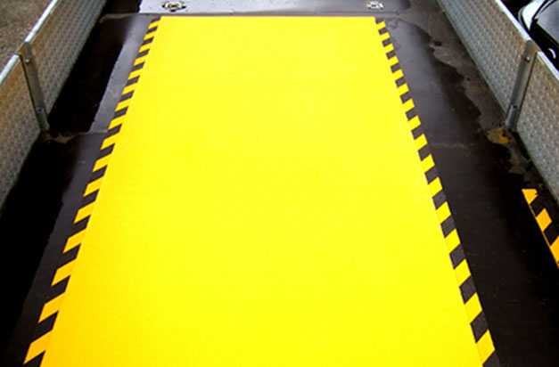 Anti-Slip floor sheets with hazard stripes for a loading area. Anti-Slip floor sheets with hazard stripes for a loading area.